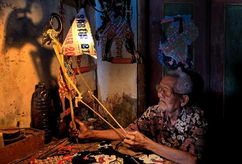 old man making puppets